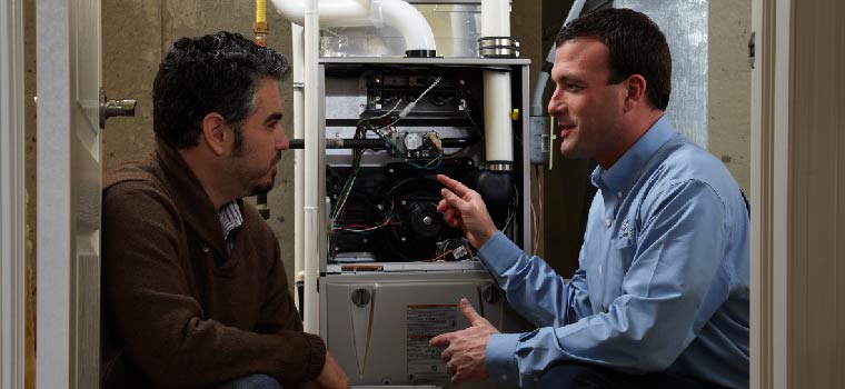 What is HVAC Maintenance? Heating technician showing customer furnace.
